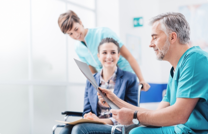 Personal médico con paciente en silla de ruedas